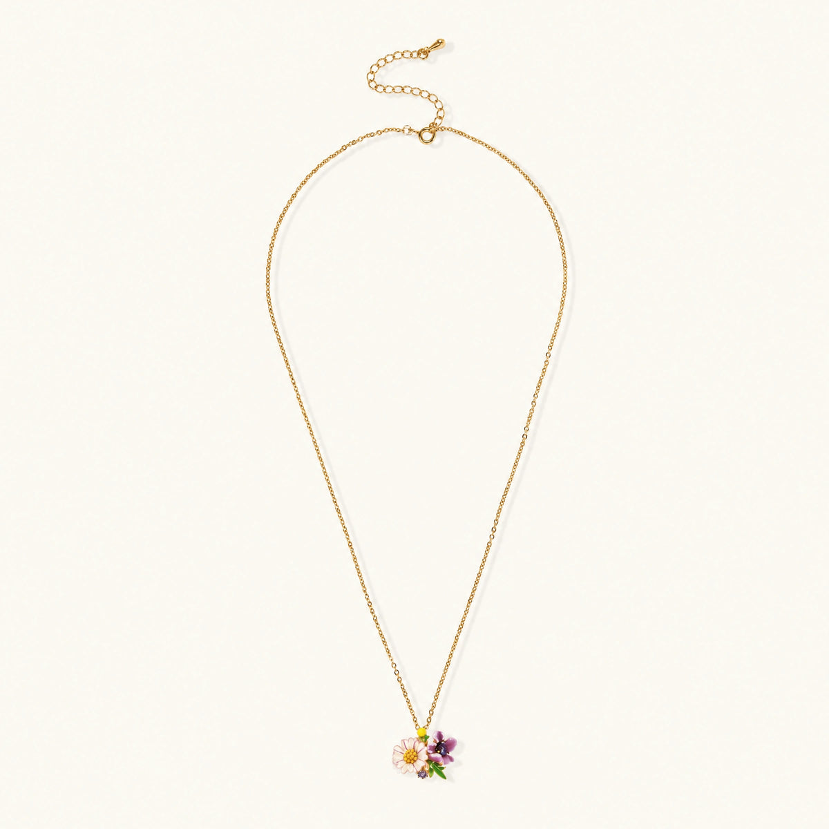 Gold-plated necklace with pink and purple enamel flower pendant featuring crystal accents on cream background